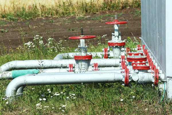 close-up of pipes and valves in a field on a background of grass in the summer