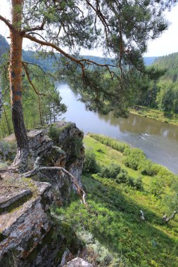Yaz dağı manzarası Urallar 'daki İdrissova Mağarası, nehir ve orman güneşli bir günde tepeden manzara