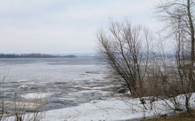 Baharın başlarında bulutlu bir günde nehir üzerindeki buz tabakası sürükleniyor.