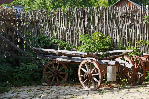 夏の日差しの中で錆びた部品を積んだ古い木製のカートの車輪の閉まり — ストック写真