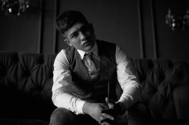 Lüks takım elbiseli bir iş adamı ve kütüphanenin içinde pahalı bir kitabı var.