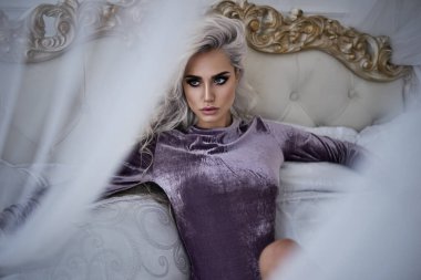 Lüks iç çamaşırları. Uzun saçlı ve zayıf vücutlu güzel sarışın barbi kız. Pembe ayakkabılar ve mor iç çamaşırlarıyla.