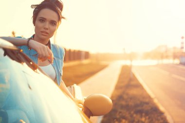 Gün batımında Cabrio 'nun arabasında oturan genç güzel kız arkadaşlarını bekle ve mükemmel bir hafta sonu düşün.