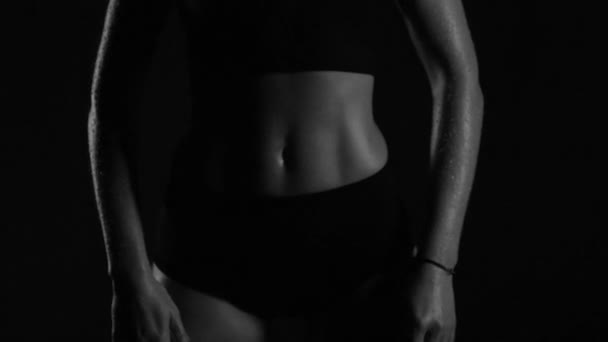 体とその中のすべての筋肉を示す水滴の下で強力な筋肉体のポーズとトレーニングを持つ美しい女の子 — ストック動画
