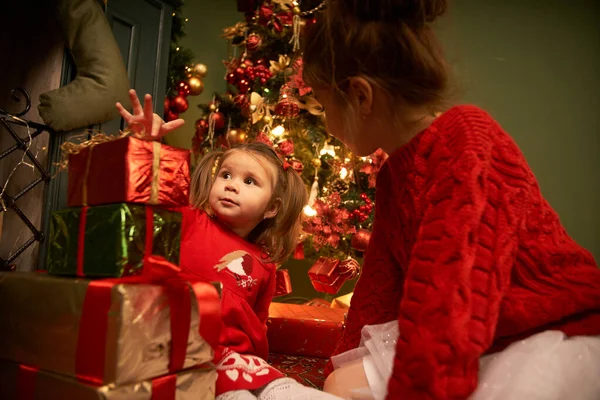 Hermanitas Desempaquetan Regalos Sonríen Ambiente Acogedor Navidad Año Nuevo Guirnaldas — Foto de Stock