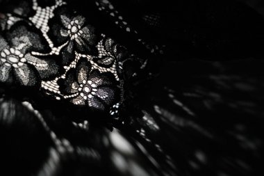Abstract background of shadows black floral laces on white table. Light going through black lace. Romantic, passion background for sites, flyers, package clipart