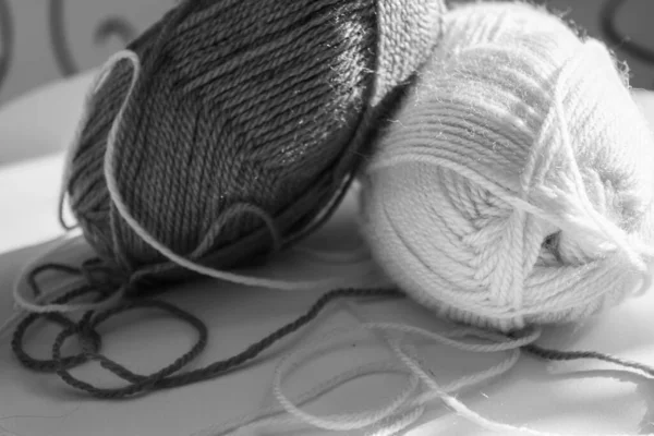 Skeins of white and grey wool yarn. Alpaca, Merino yarn. Threads for knitting and crocheting. Creativity and Hobbies