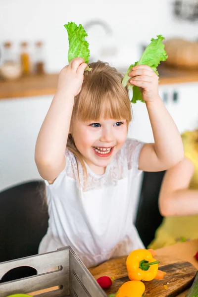Aranyos Gyerek Kislány Játszani Zöld Saláta Mint Egy Nyuszifül Konyhában — Stock Fotó
