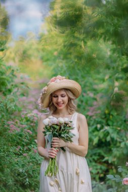 Çiçekli şapkalı ve retro elbiseli güzel bir kız bir kır evinin bahçesinde dinleniyor. Yeşil ve pembe şekerlemelerle çevrili cam bir tabakta kırmızı olgun çileklerin olduğu bir masada otururken, bir yudum su ve şakayık... 