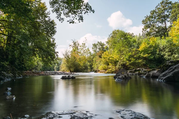 Lunga esposizione al paesaggio fiume rocce acquatiche setose e vegetazione — Foto Stock