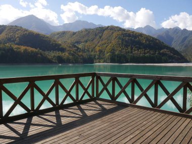 Barcis Gölü panoramik ahşap balkon gölün turkuaz suyu üzerinde