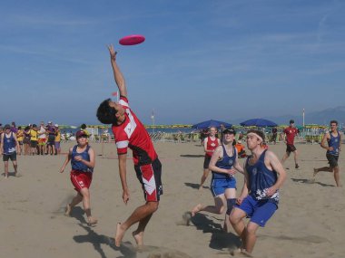 Burla Beach Cup 2019 - Athletes of Warwick Bears UK team ( Mixed division ) playing with the disc during a Beach Ultimate Tournament in Torre del Lago, Italy. clipart