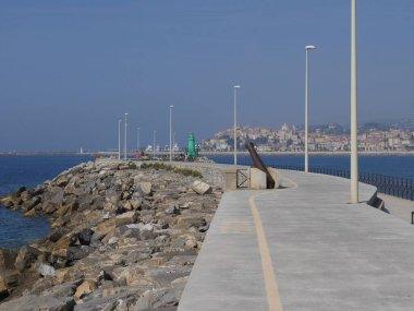 Arka planda Parasio Dağı olan Imperia Oneglia 'nın deniz fenerine giden iskeledeki antik demir top.