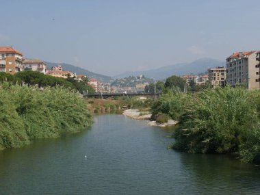 Imperia Porto Maurizio 'yu Imperia Oneglia' dan ağaçlandırılmış nehir kenarları ve köprü ile ayıran Impero Torrent