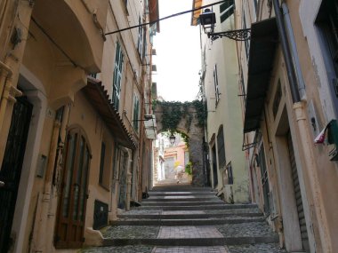 Sanremo - Pigna adında eski bir kasabada tipik bir cadde. Renkli binaların arasında kemerlerle kaplı taş merdivenler var.