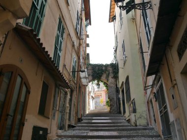 Sanremo - Pigna adında eski bir kasabada tipik bir cadde. Renkli binalar ve bahçeleri arasında kemerler var.