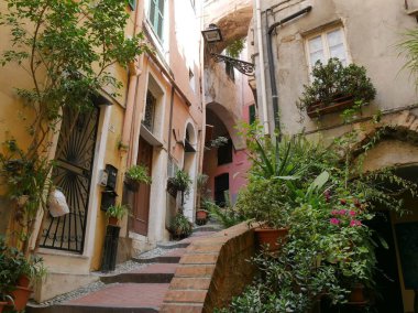 Sanremo - Pigna adında eski bir kasabada tipik bir cadde. Renkli binalar ve bahçeleri arasında kemerler var.