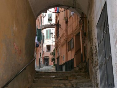Sanremo - Pigna adında eski bir kasabada tipik bir cadde. Renkli binaların arasında kemerlerle kaplı taş merdivenler var.