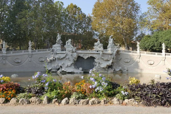 トリノ12ヶ月バレンティーノ公園の秋の色を持つ植生の間で白い装飾石で作られた噴水 — ストック写真