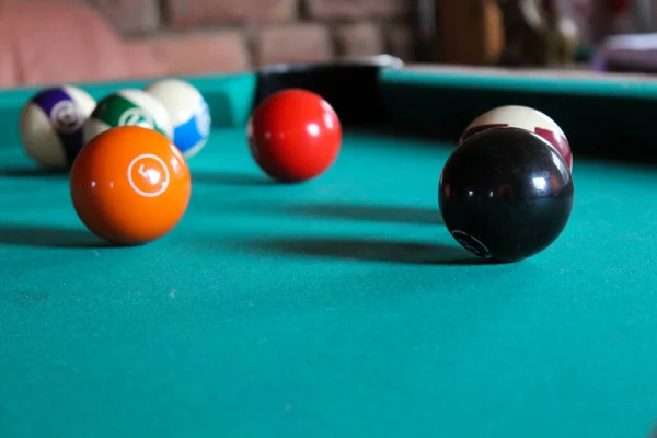Pool billards balls on a pool table with green cover close up.