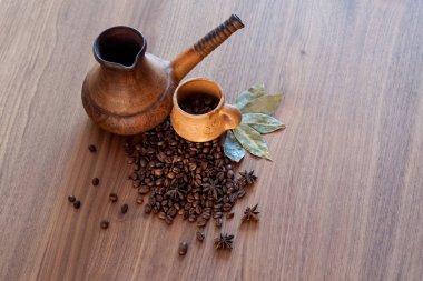 Kahve çekirdekleri ahşap bir masaya döküldü. Baharatlı ve fincanlı.