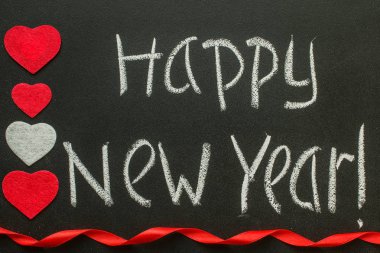 Bir kara tahta üzerinde mutlu yeni yıl el yazısı.