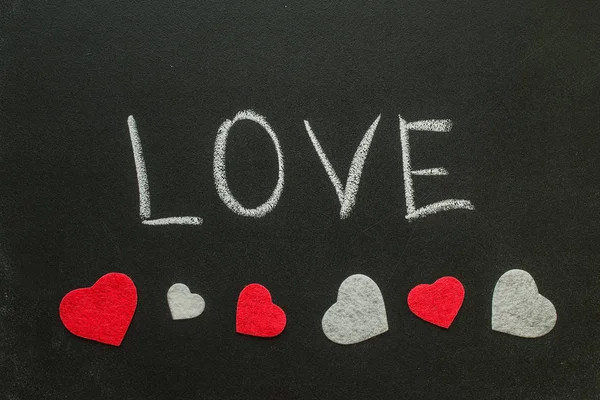 La palabra amor con corazones en la pizarra — Foto de Stock