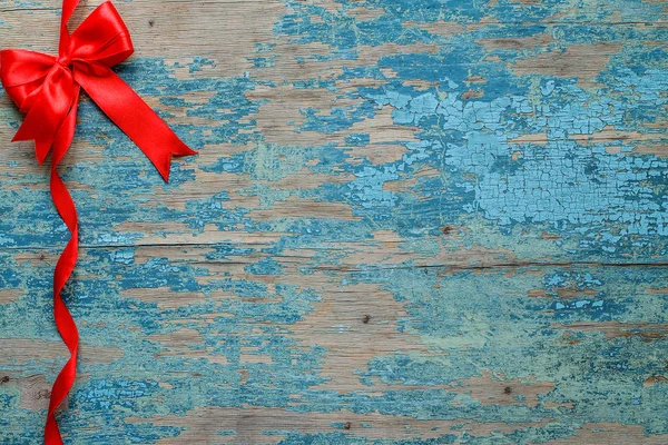 Декоративная красная лента и лук на деревянном фоне — стоковое фото