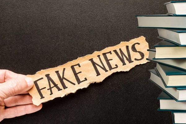 Torn paper with text FAKE NEWS. — Stock Photo, Image