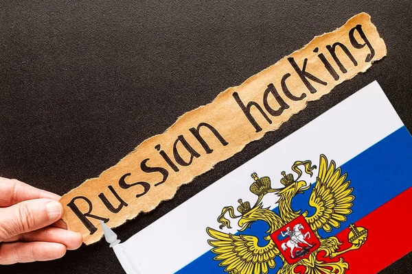 RUSSIAN HACKING inscrição em folha de papel rasgado — Fotografia de Stock