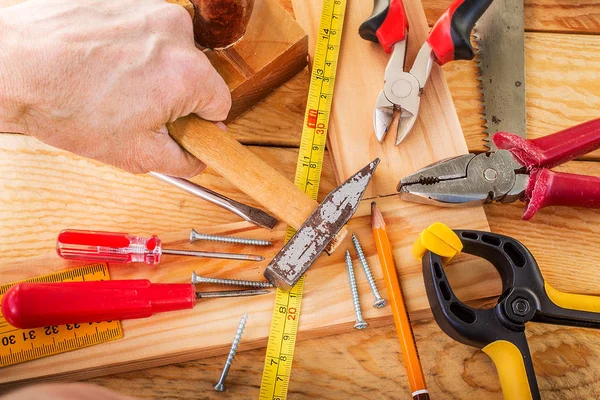 Mão de homem trabalhando na mesa do carpinteiro e ferramentas de trabalho . — Fotografia de Stock
