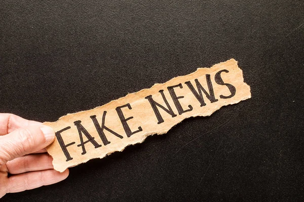 Torn paper with text FAKE NEWS — Stock Photo, Image