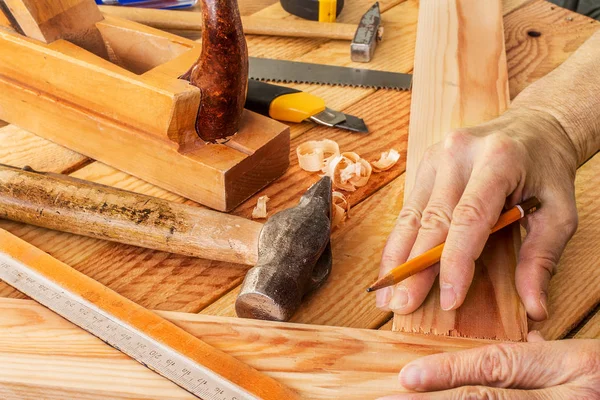 Mano de hombre trabajando en el escritorio del carpintero y herramientas de trabajo — Foto de Stock