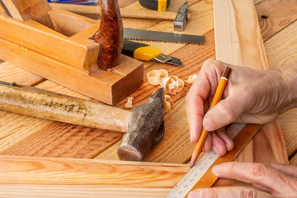 Mano dell'uomo che lavora sulla scrivania del falegname e sugli strumenti di lavoro . — Foto Stock