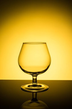 Sarı arka plan üzerinde boş şarap kadehi