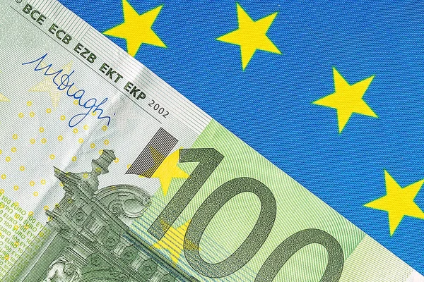 Vlajka EU a množství eurobankovek — Stock fotografie