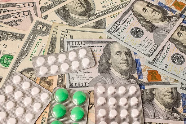 Round medicine tablets on money — Stock Photo, Image