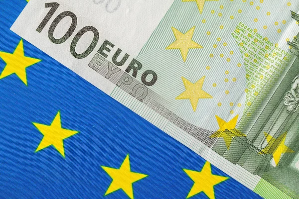 Vlajka EU a množství eurobankovek — Stock fotografie