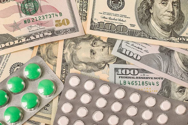 Round medicine tablets on money — Stock Photo, Image