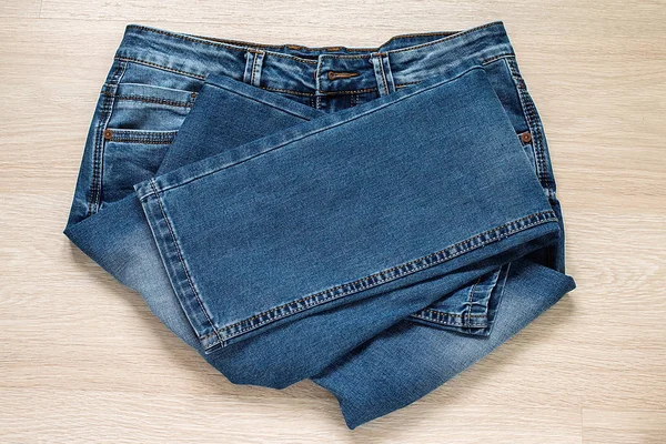 Нові блакитні джинси на дерев'яному фоні — стокове фото