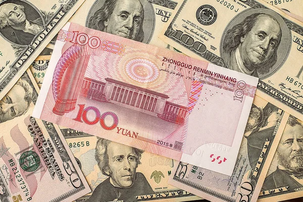 Billet de banque yuan chinois sur fond de dollars américains — Photo