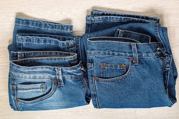 Nové modré džíny na dřevěné pozadí. — Stock fotografie