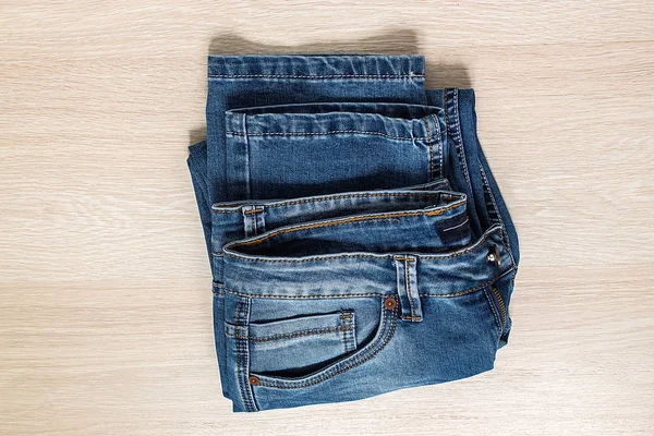 Nové modré džíny na dřevěné pozadí. — Stock fotografie