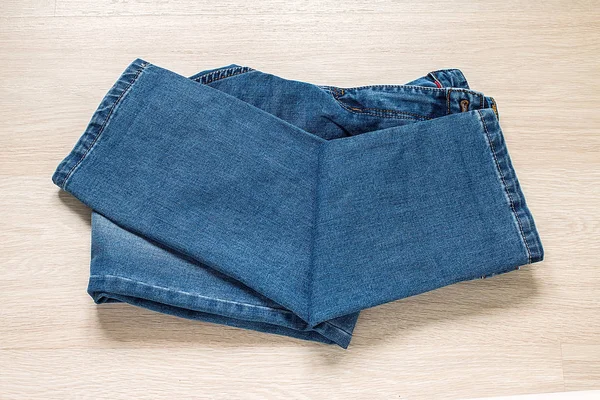 Ahşap arka plan üzerinde yeni mavi jeans — Stok fotoğraf