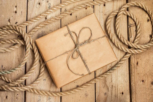Винтажная подарочная коробка и веревка на деревянном фоне — стоковое фото