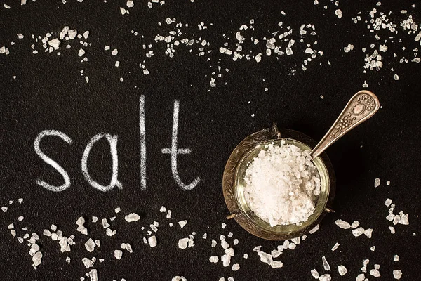 Salt in  jar on black background, top view — Stock Photo, Image