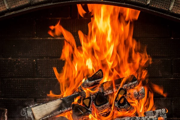 Brända ved i eldstaden på nära håll. — Stockfoto