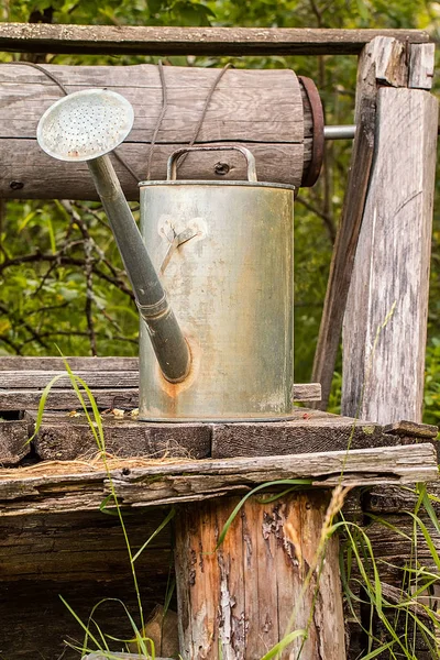 Watering pot on lod wooden background — Stock Photo, Image