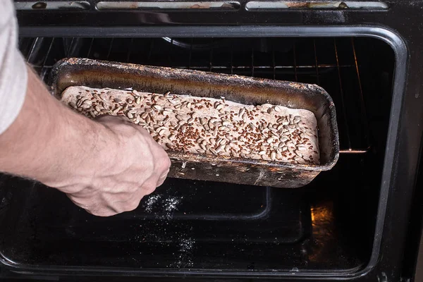 Чоловік кладе хліб у духовку — стокове фото