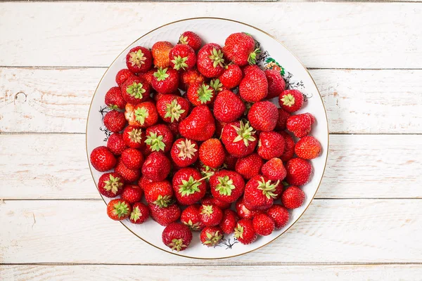 Reife Erdbeeren auf einem weißen Teller. Draufsicht, flache Lage — Stockfoto